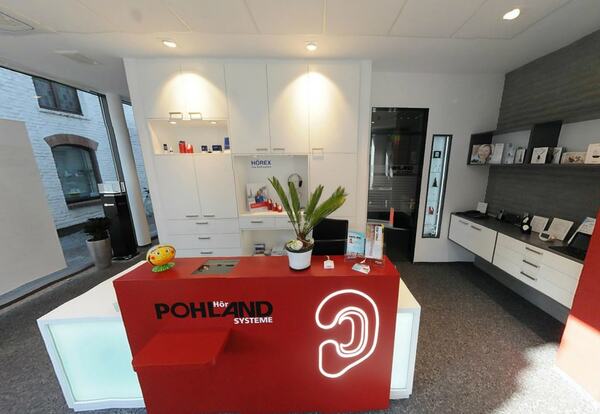 Moderner Empfangsbereich eines Hörakustik-Fachgeschäfts mit Beratungstresen und Infomaterial.